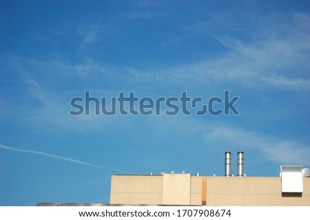 A beautiful blue sky and the corner top view of a modern design white building