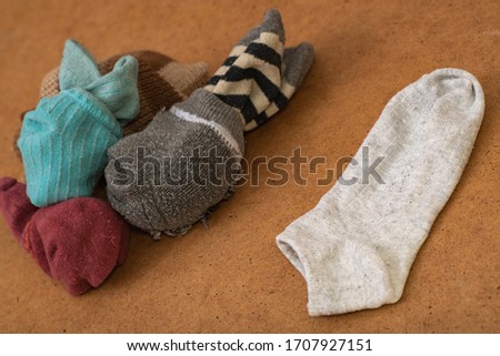 Photo with socks arranged in pairs after washing and one sock without a pair. Concept - Lost Sock and Loneliness