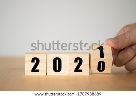 Hand flipping wooden blocks for change year  2020 to 2021 . New year and holiday concept. Royalty-Free Stock Photo #1707938689