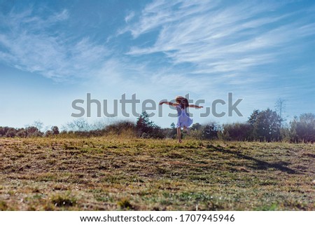 girl playing in a field on a sunny day