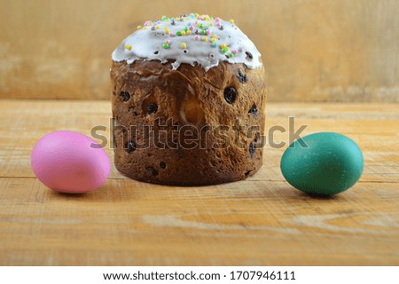 beautiful Easter cake and two eggs lie on a wooden background