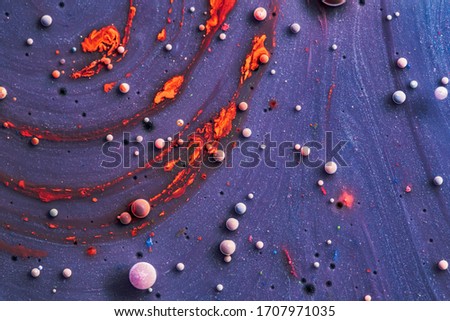  Color drops floating in oil and water over a colorful underground with oil painting effect. Macro photo