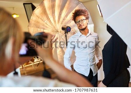 Young man posing as a model for portrait photos during the photo shoot in the studio