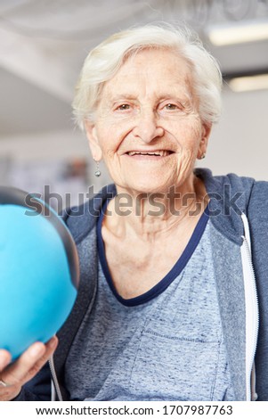 Happy senior woman with ball in occupational therapy as a rehab in the fitness center