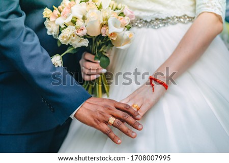 
interracial marriage, hand in hand, a bouquet of the bride Royalty-Free Stock Photo #1708007995