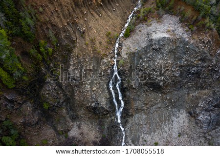 aerial view of a seasonal waterfall in the mountains in Northern California cascading down a rocky hillside