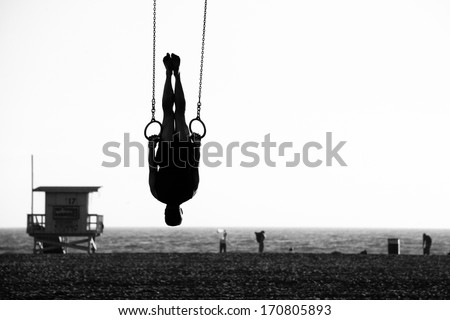 Silhouette of a person swinging on rings on the beach, Santa Monica Beach, Santa Monica, Los Angeles County, California, USA