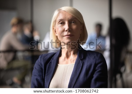 Close up headshot portrait of mature businesswoman look at camera showing confidence, middle-aged focused positive female CEO or boss, woman employee posing for picture in office, leadership concept Royalty-Free Stock Photo #1708062742