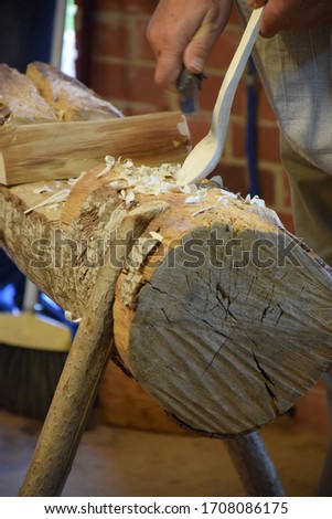 Wooden workshop. Hands carving spoon from wood, working with chisel close up. Process of making wooden spoon. Stock Photo