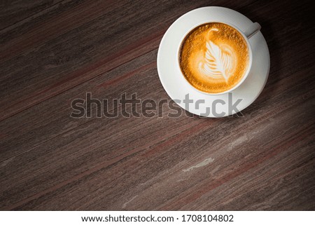 Latte arts coffee with white cup, top view closeup on wood background,Cafe and bar, barista art concept.