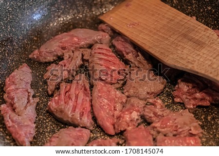 Meat Cooking in the Pot with Wood Spoon Food Concept