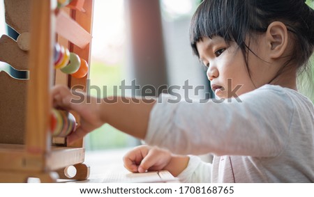Kids intend learn from play with colorful wooden toy on table desk at home. Preschool young girl concentrating with educational block in recess term back to school Children at home or daycare child. Royalty-Free Stock Photo #1708168765