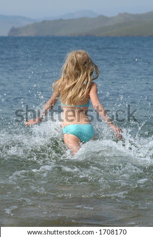 Young girl running to Baikal Lake in Siberia, Russia