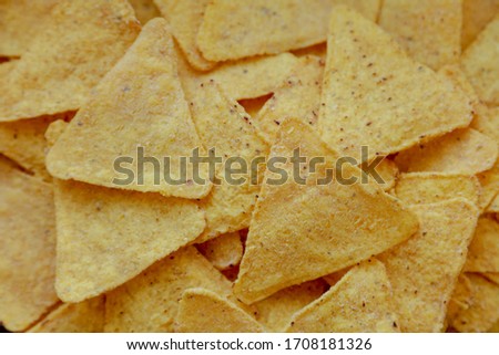 Golden crispy corn chips isolated on white background. Delicious salty mexican triangular nachos. Flat lay food photography.
