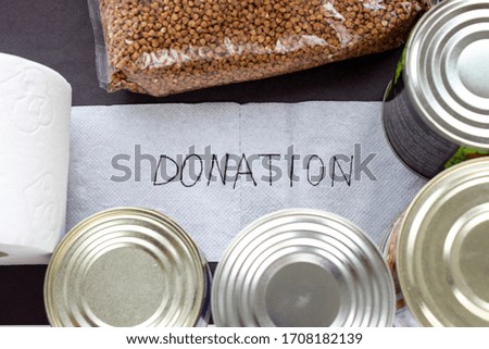 Stock of food and toilet paper on a table with a signature "donation"