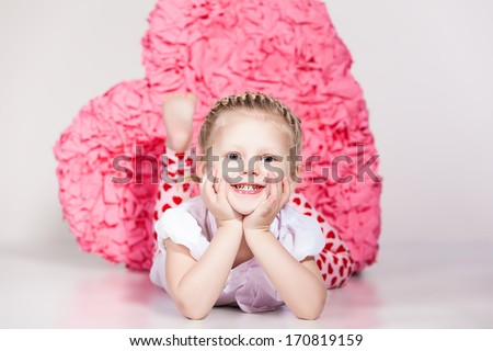 Valentine's Day. Beautiful small girl with a large red heart-shape indoor