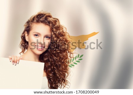 Cheerful young woman showing white banner with Cyprus flag. Travel and learn greek language