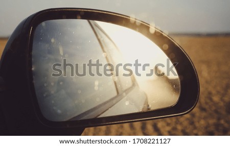 Road Dust in a Car Mirror. Photo with Film and Grain Effect