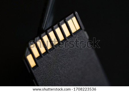 
memory black sd card for storage with gold pins on a black background