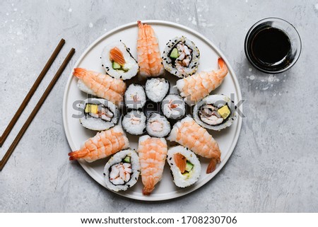 Mix of traditional japanese sushi on the light background, selective focus image.  food delivery set of sushi and rolls with salmon and shrimp. service food order online. 