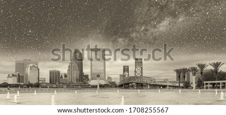 Jacksonville, Florida. Panoramic view of city downtown and brigde on a starry night with milky way, USA.