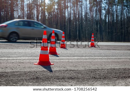 Traffic cones are exposed on the pavement during the repair of the intercity road. Highway traffic during pavement repair