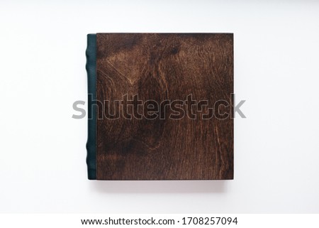 Dark wooden Photo book on the white background. Empty photo book cover. Flat lay.