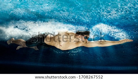 Professional man in swimming pool. Crawl swimming style. Underwater Royalty-Free Stock Photo #1708267552