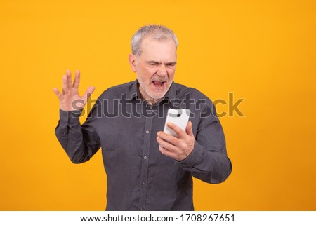 adult or senior man with mobile phone isolated on color background