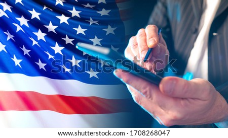 Man with a phone on the background of the USA flag. Concept - US telecommunications company. Mobile networks in America. Concept - shares of mobile operators. Businessman holds phone in his hands.