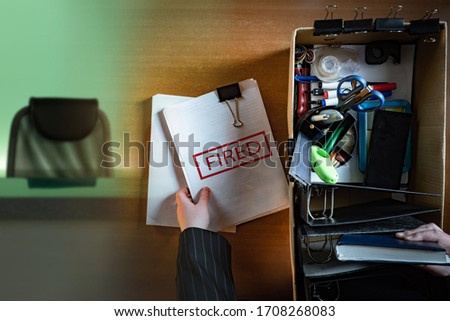 Order of dismissal. Inscription fired on documents. Man lost his job. Human collects things from his desktop into a box. Man found out that he no longer has a job. Concept - loss of source of income