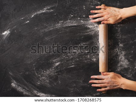 Bakery black background with roll and famale hands flat lay, top view, copy space, banner Royalty-Free Stock Photo #1708268575
