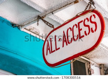 Exterior signage, ALL ACCESS. Hanging from the ceiling by steel chain. Low angle view, background, copy space.