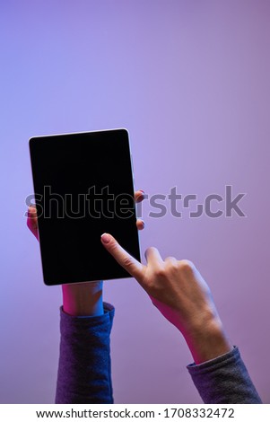 Close-up of man's hand with phone and black screen on empty purple background