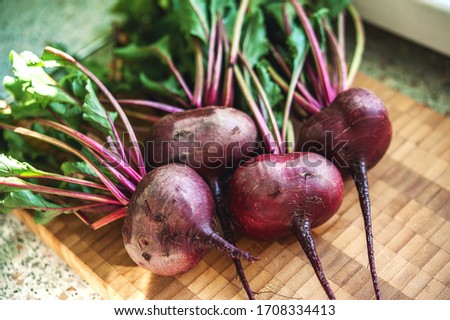 beet harvest with green tops on a wooden board Royalty-Free Stock Photo #1708334413