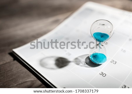 Hour glass on calendar concept for time slipping away for important appointment date, schedule and deadline Royalty-Free Stock Photo #1708337179