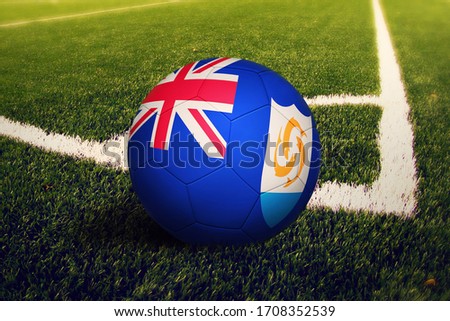 Anguilla flag on ball at corner kick position, soccer field background. National football theme on green grass.