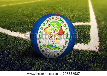 Belize flag on ball at corner kick position, soccer field background. National football theme on green grass.