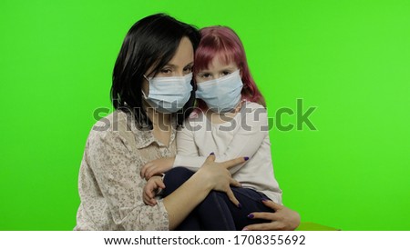 Sick mother embrace daughter in medical mask. Coronavirus concept. Young family quarantine. A virus illness. Disease. Epidemic. Sad woman hug child. Chroma key. Green screen