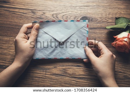 woman hand letter and rose on the desk