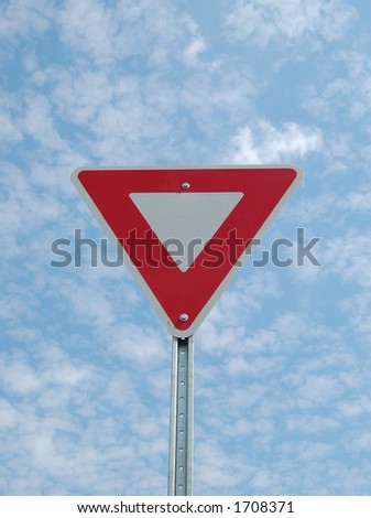 Yield sign against cloudy sky