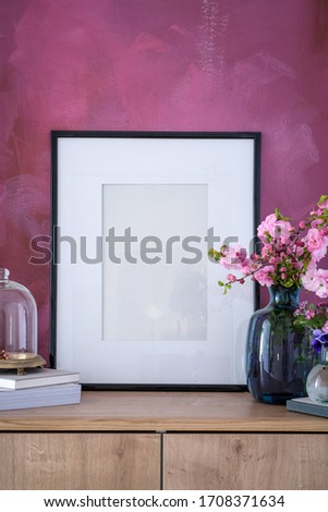 Empty frame on a dresser in an interior