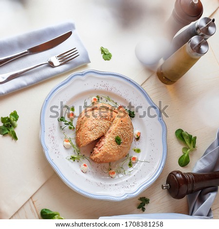 Burger cut with vegetables on a light background.
