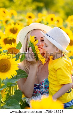 beautiful mbeautiful mother holds a baby son in a sunflower field. tenderness, smiles, happinessother holds a baby son in a sunflower field. tenderness, smiles, happiness