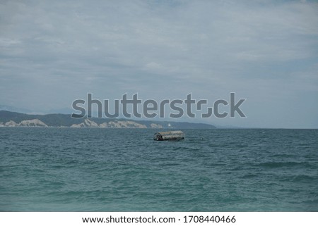 
Boat sailing on the sea against the backdrop of mountains in cloudy weather