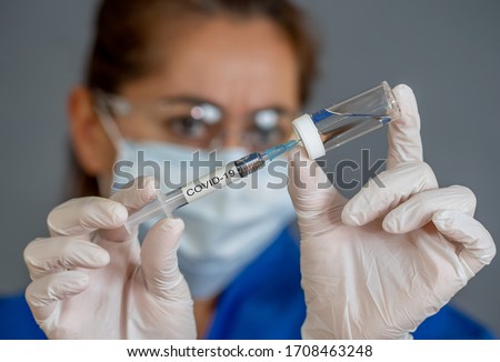 COVID-19 Coronavirus Vaccine. Doctor scientist with syringe analyzing virus Sars-CoV-2 in research for vaccine to be ready for clinical trial. Female researcher testing potential vaccine at the lab. Royalty-Free Stock Photo #1708463248