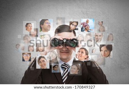 Human resources, CRM, assessment center and social media concept - business man looking for employees through binoculars. Lots of people portraits around him Royalty-Free Stock Photo #170849327