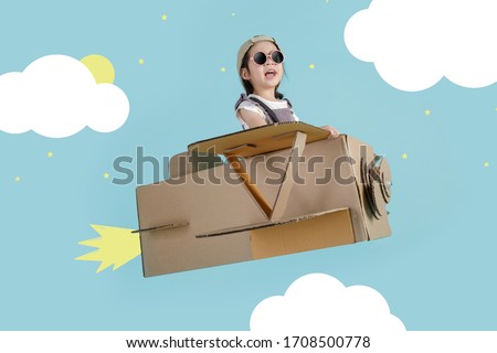 Asian little child girl playing with cardboard toy airplane handicraft over the clouds, Creative at home and dreams of flight concept Royalty-Free Stock Photo #1708500778