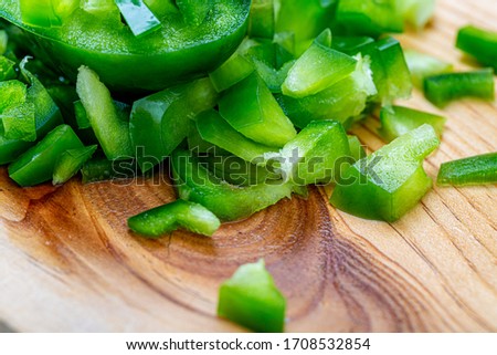 Health vegetarian food. Sweet green pepper sliced small pieces on a wet wooden board. A juicy bell pepper. Shallow depth of field. Copy space. Closeup. Macro. Soft focus.