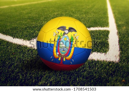 Ecuador flag on ball at corner kick position, soccer field background. National football theme on green grass.
